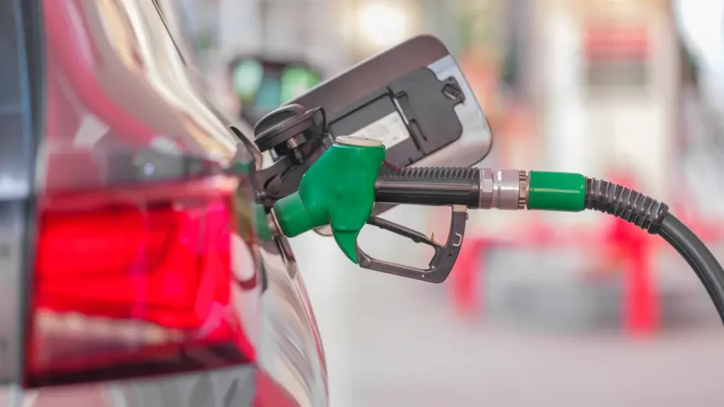 Degalų pildymo procesas degalinėje naudojant kuro pistoletą ir lengvąjį automobilį.