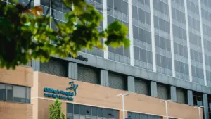Modernaus terapijos centro pastatas Vilniuje su dideliais stikliniais langais šiuolaikiškame mieste.