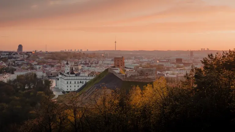 Vaizdas į Gedimino pilies bokštą Vilniuje saulėlydžio metu virš miesto panoramos