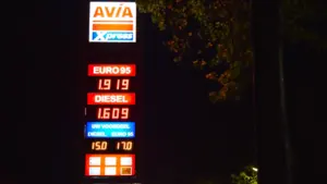Degalų kainas rodantis šviečiantis degalinės stulpas tamsiu paros metu Europos mieste