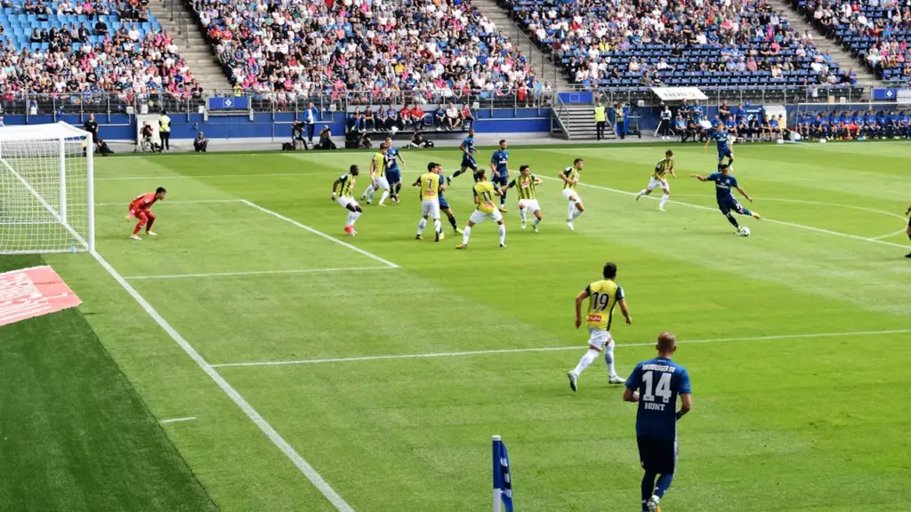 Futbolo rungtynių vaizdas iš tribūnų su abiem komandomis aikštėje